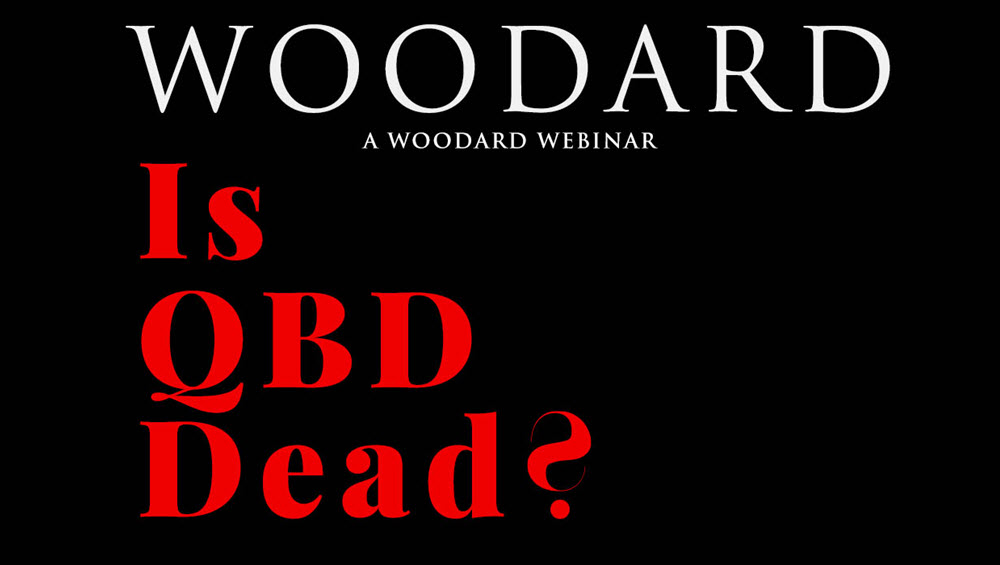 A very dark graphic - in face the background is only black. Top third of the horizontal image is the word 'woodard' in white thin text with the lower 2 thrids in large thick red font says 'is QBD dead?'